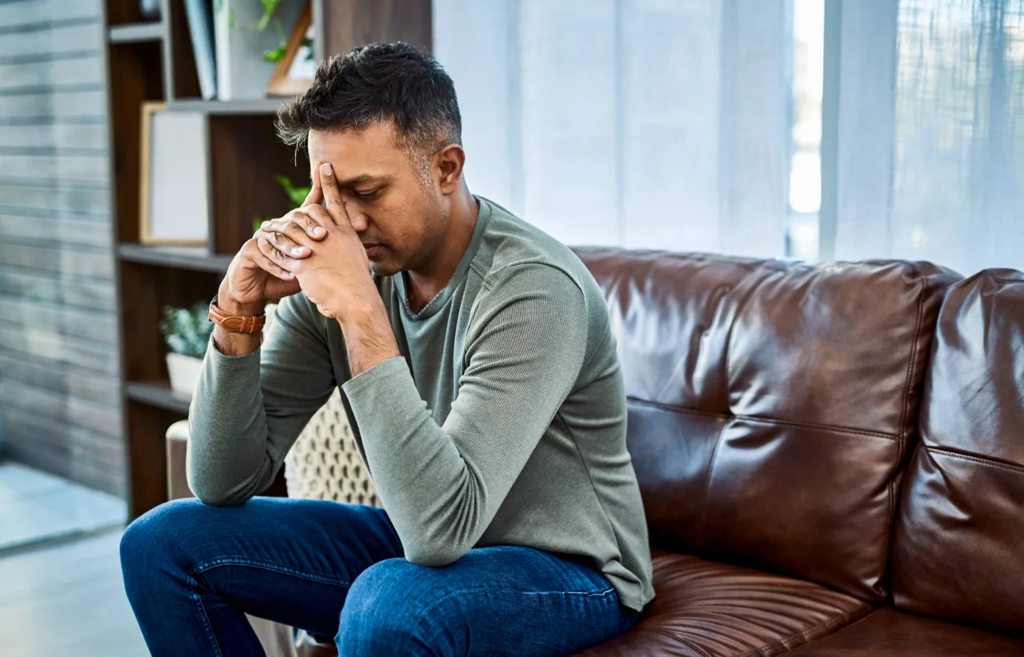 man thinking while pressing into temple